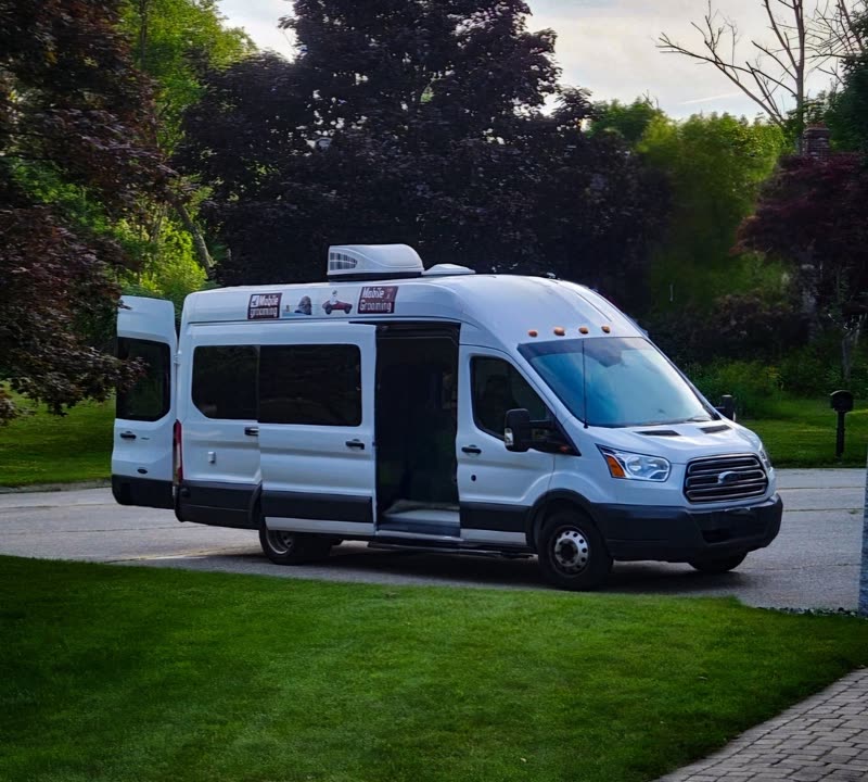 The white mobile grooming van parked on a driveway
